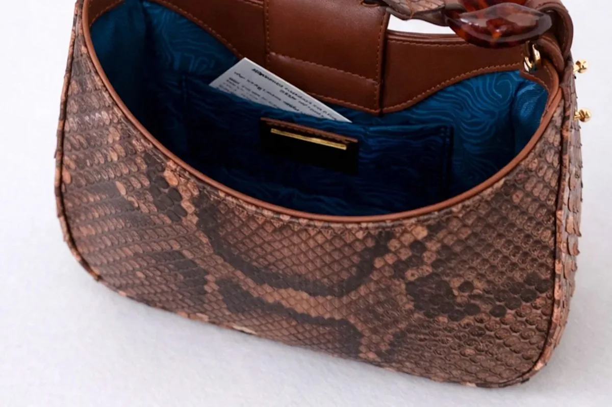 Woman holding a luxury handbag made from Burmese python skin in South Florida